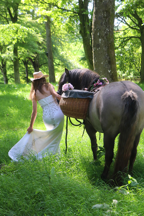 Bride with highland pony walking through woodlands on Kinclune Estate